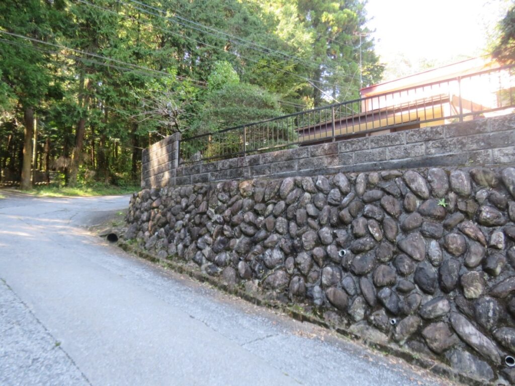 右の石垣の上のお家です